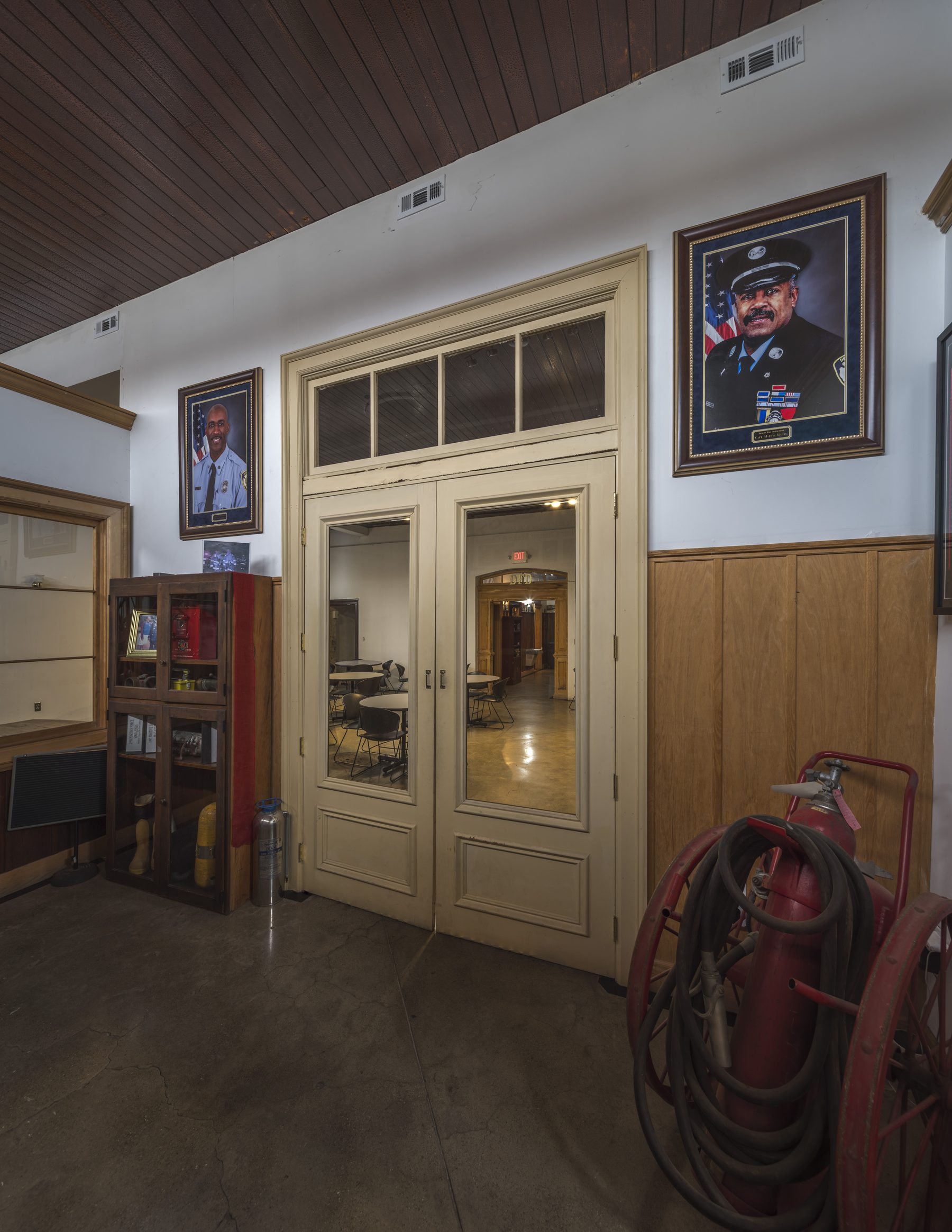 The foyer at Historic Engine 11 — honored Phoenix legacy portraits, including Capt. Marvin Massey, flanking the ornate doors that open onto the banquet hall.