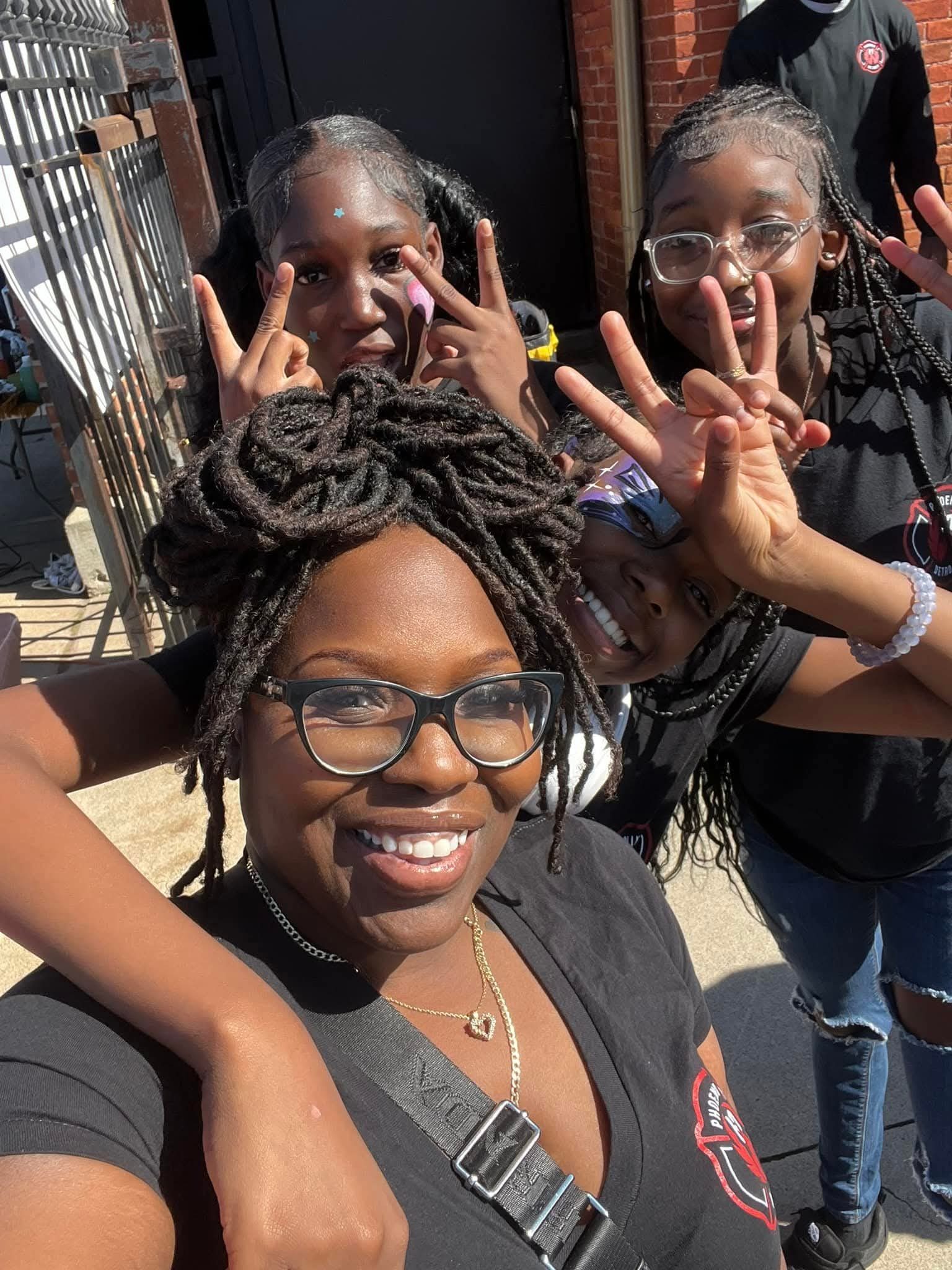 Phoenix community outreach — joyful moment with young Detroit attendees at an outdoor event.