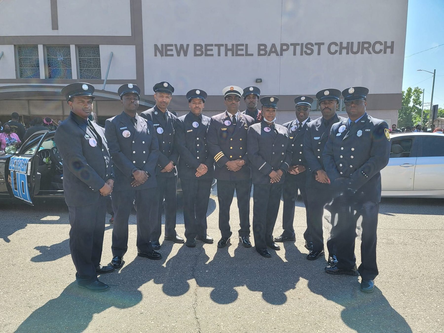 Phoenix members in full Class A dress uniform standing together in front of New Bethel Baptist Church.